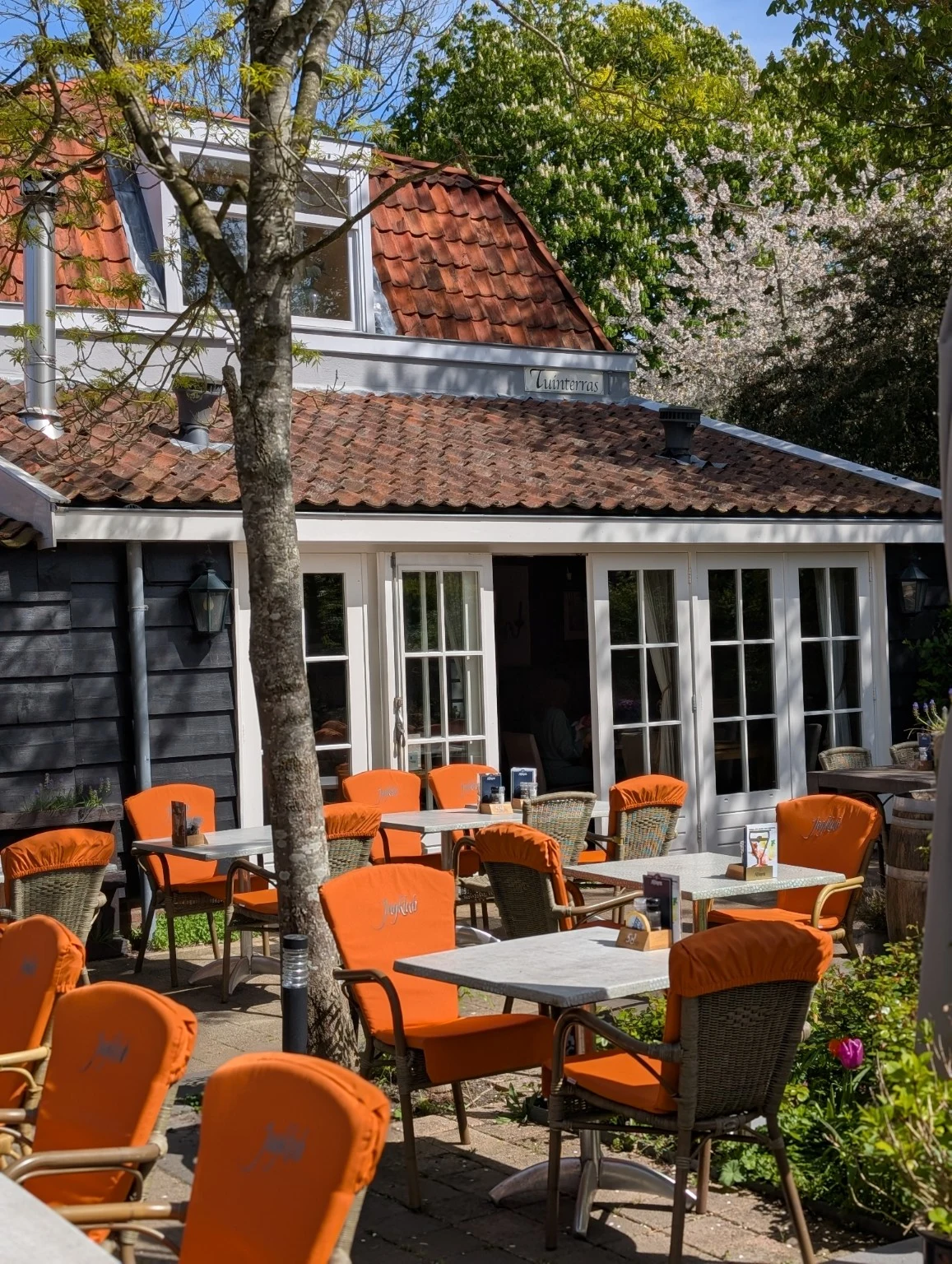 De binnentuin van De Peperboom met oranje stoelen en groen